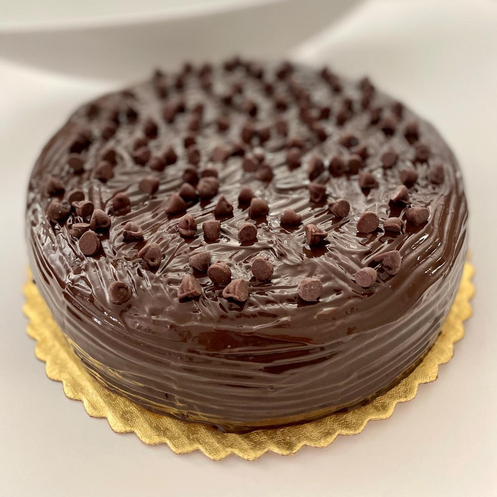 Gluten-free, sugar-free, dairy-free Chocolate Lovers Full Life cake with organic dark chocolate and sugar-free chocolate chips, topped with sugar-free chocolate syrup, offering a rich and moist texture. Full Life Gourmet Bakery