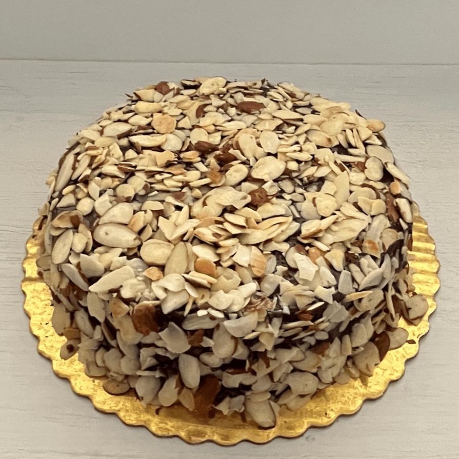 Gluten-free, dairy-free, sugar-free Vanilla Caramel Full Life Cake with a sugar-free caramel syrup drizzle and toasted almonds, showcasing its spongy texture and rich vanilla aroma. Full Life Gourmet Bakery